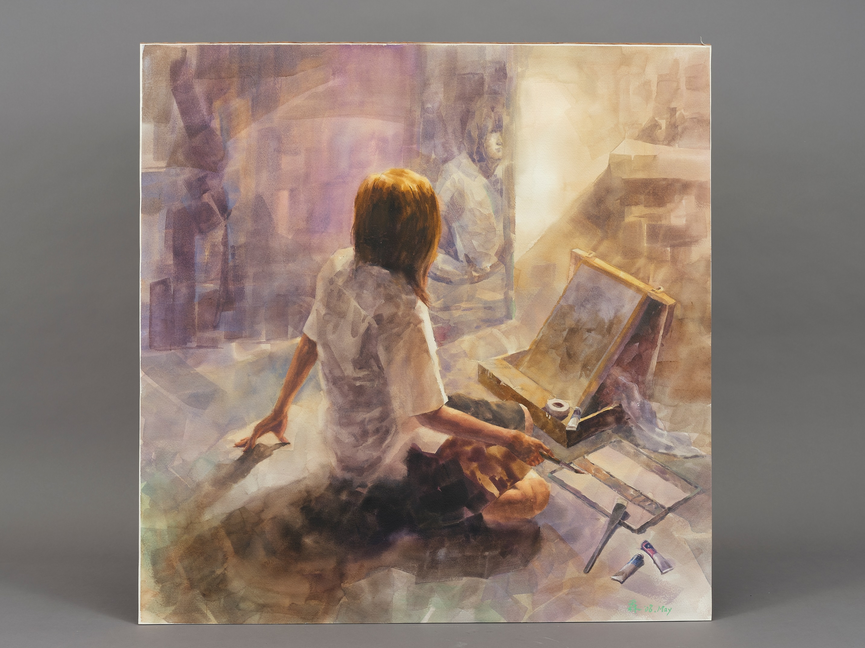 身著制服的女孩坐在鏡子前方凝視著自己，在她身體前方的是一套畫畫的工具，畫箱、畫板、畫紙、顏料、紙膠帶、調色盤、排筆，以及手上的畫筆。