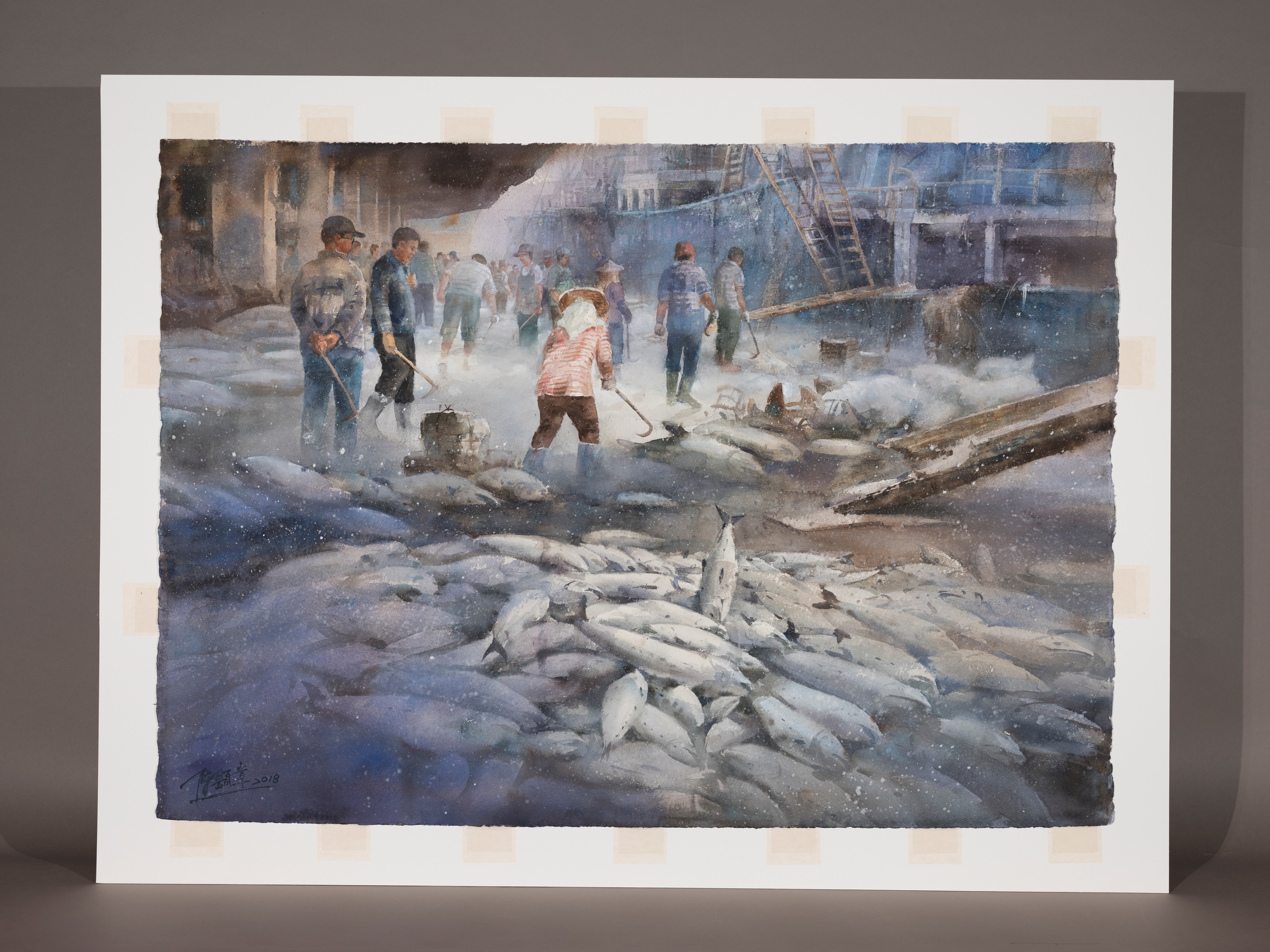 陳顯彰的水彩畫〈豐收〉捕捉了漁港的忙碌時刻，表現遠洋漁船靠港卸下的豐收漁獲。在畫面最前方是成堆的冷凍漁獲，也是構圖的最下方。